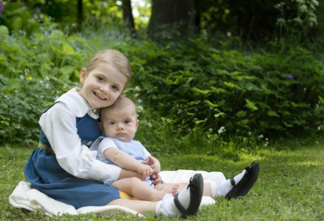 Estela, muy sonriente, sostiene en sus brazos a su hermanito, Oscar.