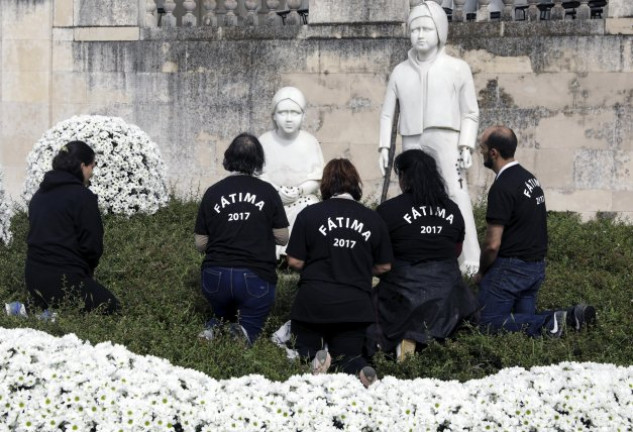 Los peregrinos rezan ante las esculturas de los pastorcillos.