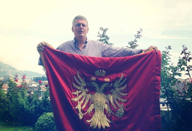 Stefan, sosteniendo una bandera de su supuesto país. 