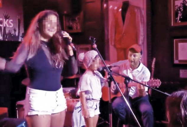 Un momento de la actuación de Dora, su hermana June y su padre, Daniel Postigo (a la guitarra).