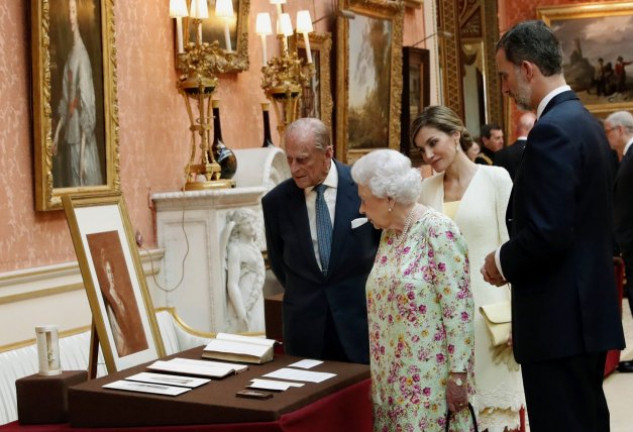 Isabel II y Felipe de Edimburgo, observando con interés el curioso presente con el que les obsequiaron los Reyes.