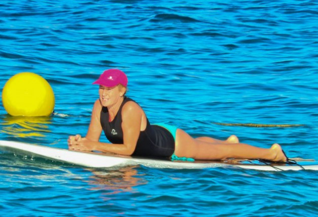 Encima de una tabla de surf, donde estuvo siguiendo clases de yoga.