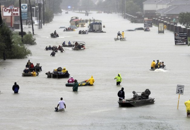 Calles inundadas y gente intentando ponerse a salvo tras la descarga de agua de la tormenta Harvey.
