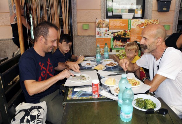 Francesco Arcuri con sus hijos, Gabriel y Daniel, y un amigo suyo, Fabio, comiendo en un bar de Carloforte.