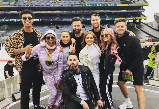 Las cuatro Spice Girls con miembros del equipo de la gira.