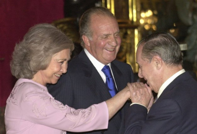 Sabino Fernández Campo, besando la mano de su quería Sofía, mientras don Juan Carlos le sonríe.