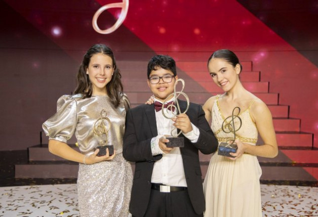 Jesús Gabriel, la finalista instrumental, Ana Flores (izqda.); y la finalista de danza, Adriana Puértolas; con sus respectivos trofeos.
