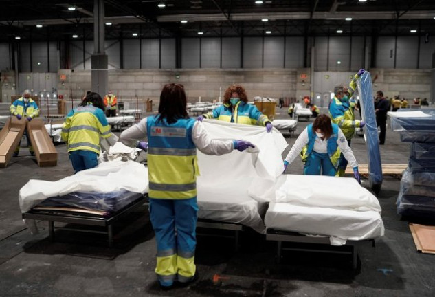 Personal sanitario prepara camas en uno de los pabellones del recinto ferial Ifema.