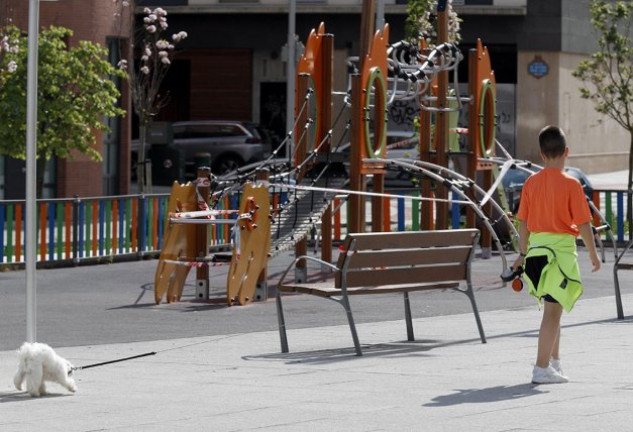 Un niño paseando un perro en un parque.