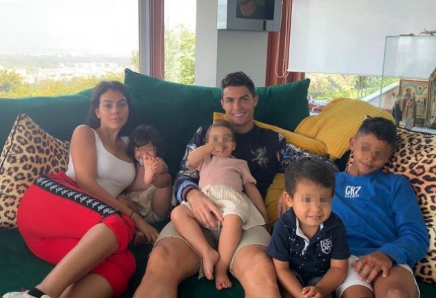 La familia Ronaldo posando al completo en el sofá de casa.