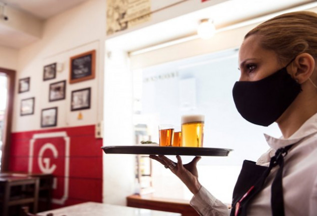 Una camarera trabajando con mascarilla en un bar del centro de Málaga
