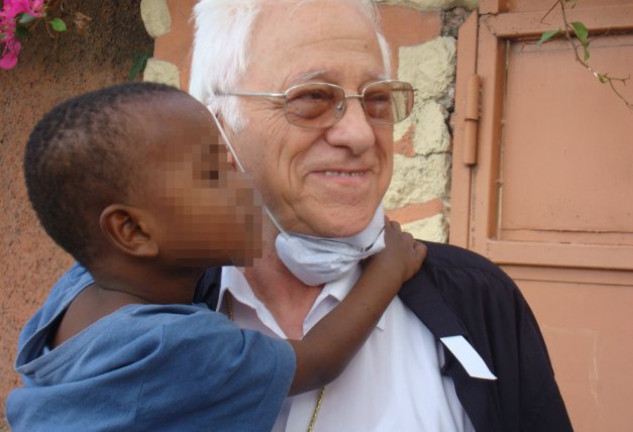 El padre Ángel sosteniendo en brazos a un niño del programa NUPAilusión.