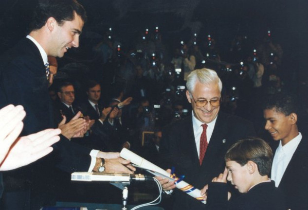 El padre Ángel con dos de sus niños recogiendo el Premio Príncipe de Asturias a la Concordia.