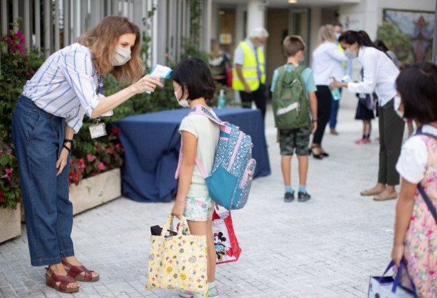 Una trabajadora toma la temperatura a una niña a la entrada del colegio privado internacional American School of Barcelona.