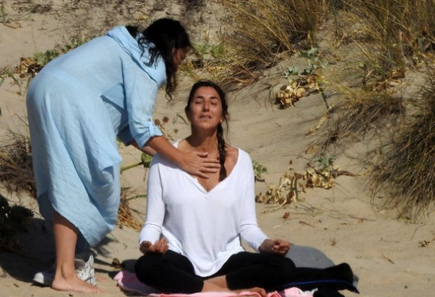 La instructora corrige la postura de la presentadora.