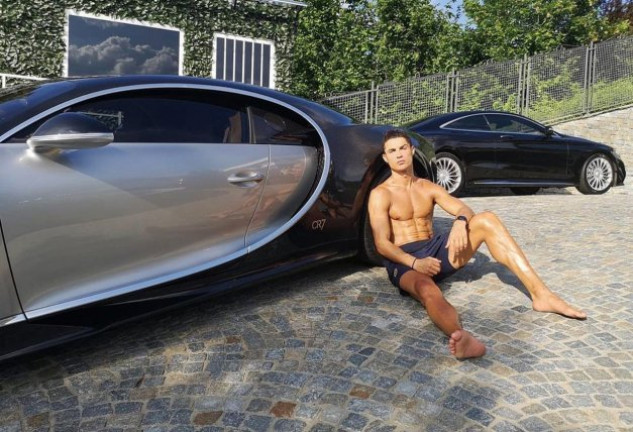 Cristiano Ronaldo, posando junto a dos de sus coches de lujo.