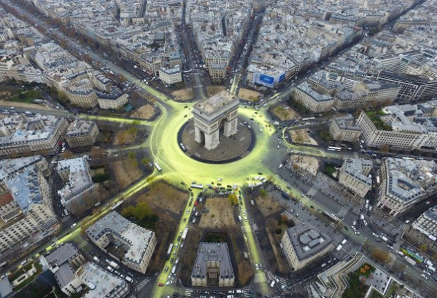 Activistas pintan un sol en el arco de Triunfo de Paris para demandar a las políticos el uso de energías renovables.