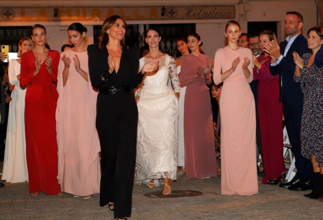 Álvaro (a la derecha de la foto) aplaude con orgullo a María José, que sonríe, feliz, tras finalizar el desfile de presentación de su última colección.