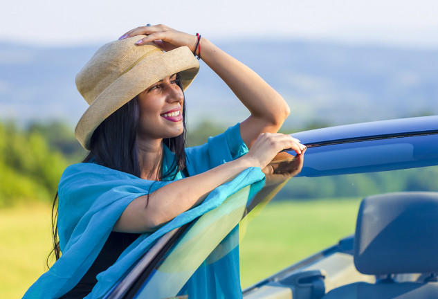 chica con un gorro en la cabeza al lado de su coche