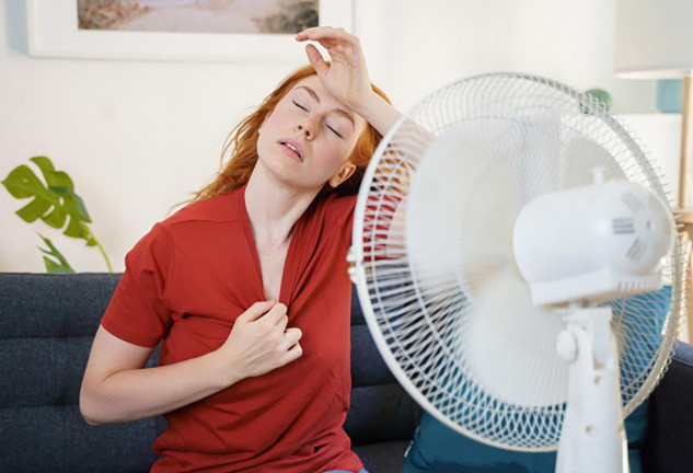 Chica acalorada delante del ventilador