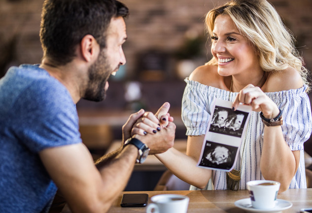 Pareja con ecografías del feto de un bebé