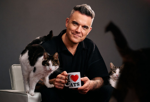 Robbie Williams rodeado de gatos.