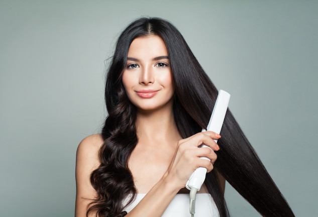 Chica planchándose el pelo.