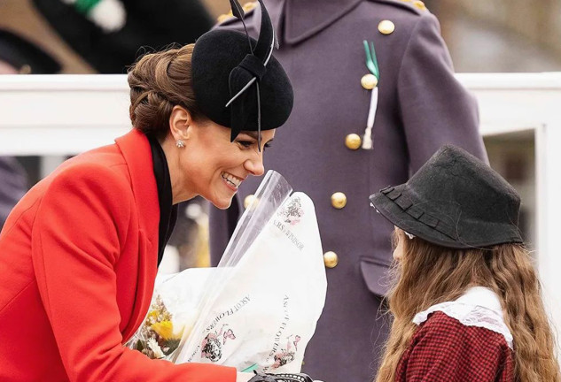 Kate Middleton saludando a una niña que le regaló un ramo de flores