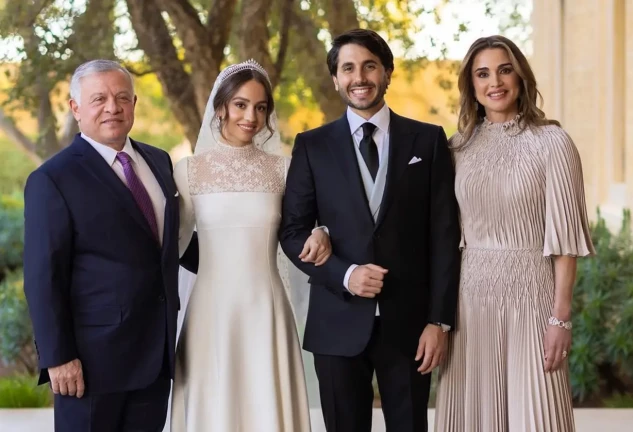 Rania de Jordania con su hija y su hierno posando el día de su boda.