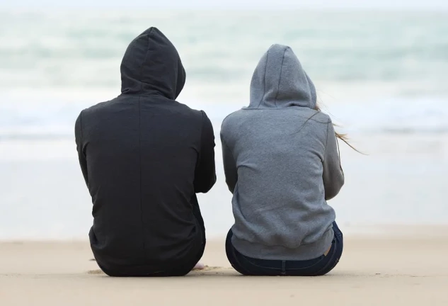 Jóvenes de espaldas en la playa.