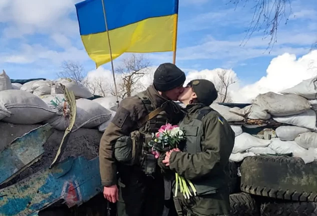 Soldados ucranianos enamorados besándose en una trinchera