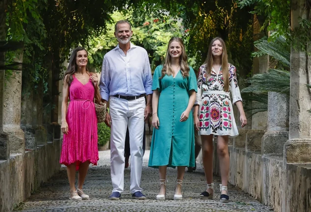 La familia real paseando por un jardín.