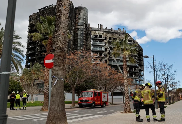 bomberos delante edificio quemado