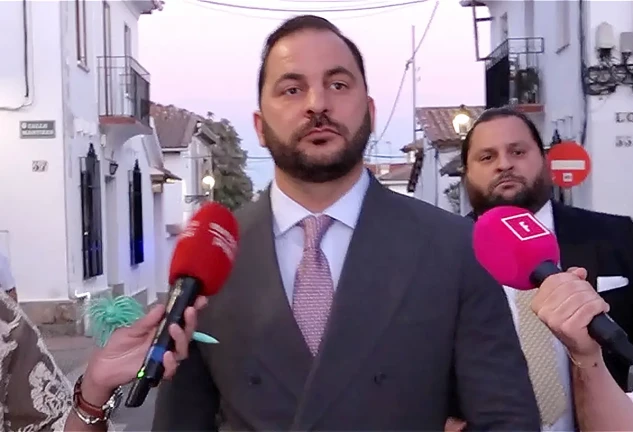 Antonio Tejado andando por la calle rodeado de periodistas con micrófonos
