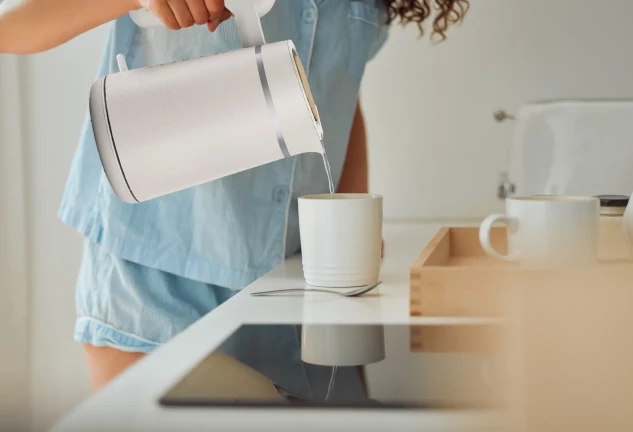 Mujer sirviendo agua de un hervidor