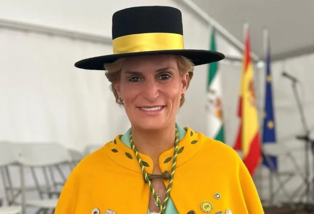 María Zurita con sombrero y capa amarilla en una imagen de redes