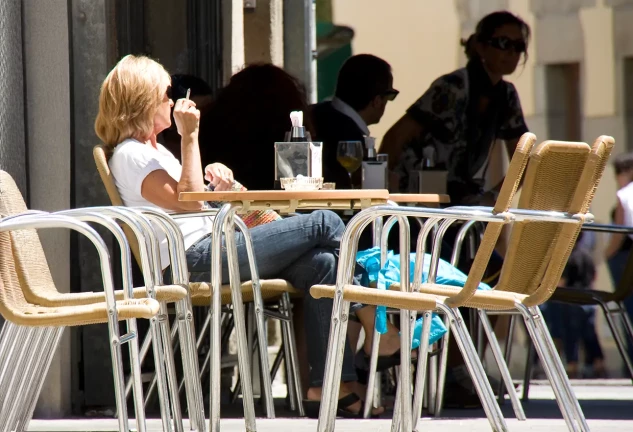 Mujer fumando en la terraza de un bar