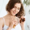 Mujer poniéndose aceite para el pelo