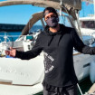 Antonio Orozco posando con mascarilla frente al velero con el que está navegando.