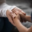 Adulto sosteniendo las manos de un niño.