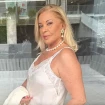 Bárbara Rey posa muy guapa con un vestido blanco y el cabello liso.