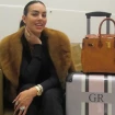 Georgina Rodríguez posando con una maleta y un bolso sentada en un sillón