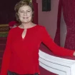 Paca Gabaldón posando en un teatro con una blusa de color rojo.