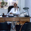 El doctor Puga en su despacho, hablando por teléfono.