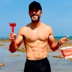 Roberto Leal con un rastrillo y un cubo en la playa.