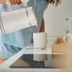 Mujer sirviendo agua de un hervidor