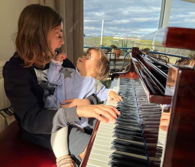 Jan Orozco y su hermanita Antonella frente al piano.