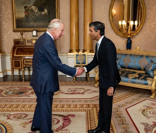 Carlos de Inglaterra saludando al ministro de la India.