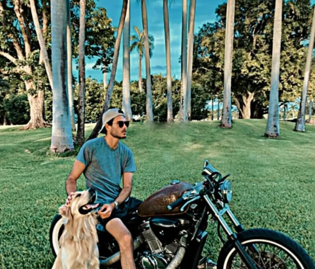 Miguel Alejandro posando montado en su moto y acompañado de su perro.