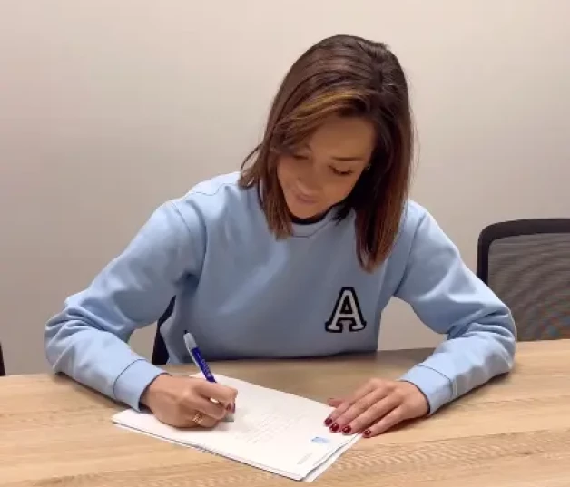 Adara Molinero firmando la compra de sus pisos.